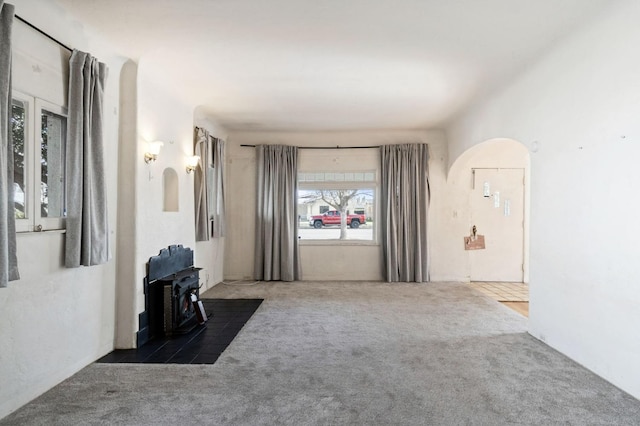 interior space featuring carpet and arched walkways