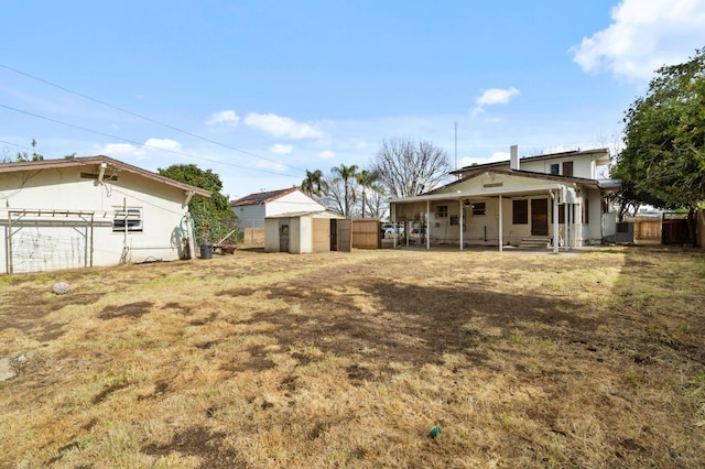 view of yard with an outdoor structure, a storage shed, and fence