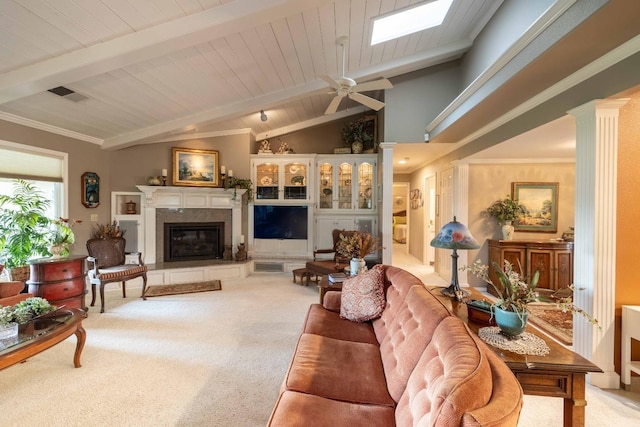 living area featuring decorative columns, visible vents, lofted ceiling with skylight, a premium fireplace, and carpet floors