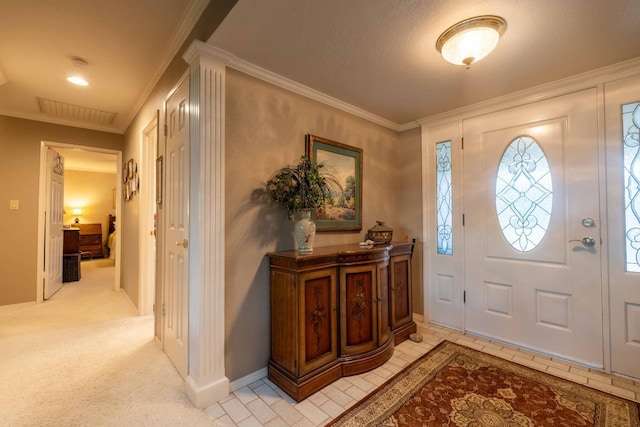 foyer entrance featuring light carpet, crown molding, visible vents, and baseboards