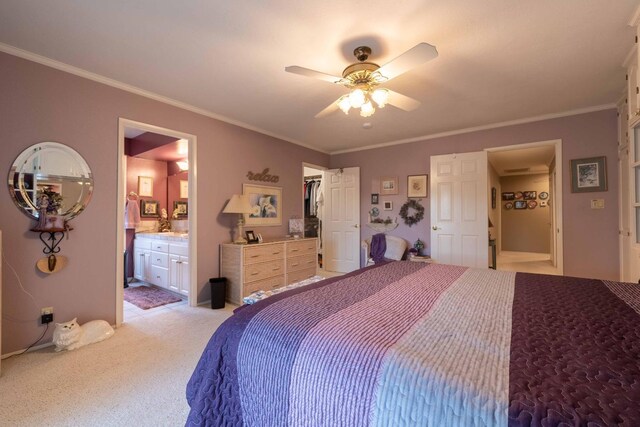 bedroom with light carpet, ensuite bathroom, a walk in closet, and crown molding