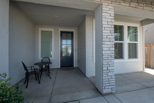 doorway to property with fence and stucco siding