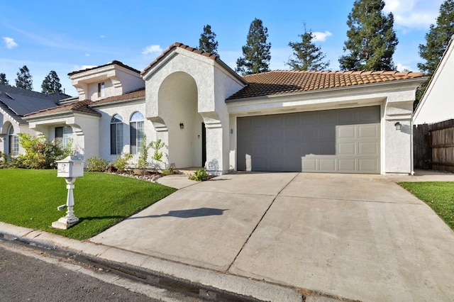 mediterranean / spanish-style house featuring a tile roof, stucco siding, concrete driveway, a garage, and a front lawn