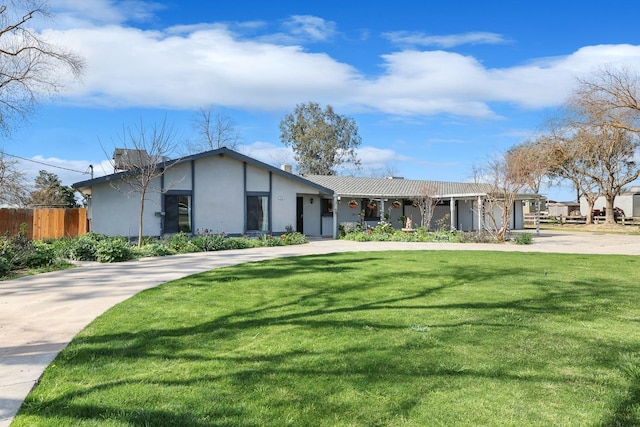 view of front facade featuring concrete driveway, a front lawn, fence, and stucco siding