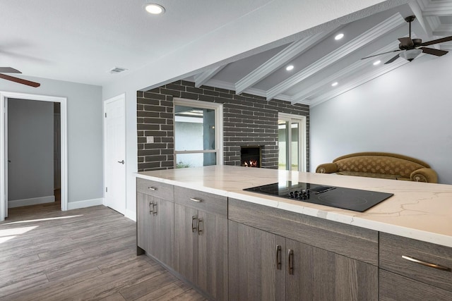 kitchen with vaulted ceiling with beams, wood finished floors, ceiling fan, and black electric cooktop