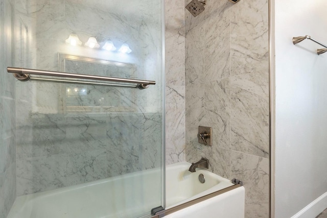 bathroom with bath / shower combo with glass door