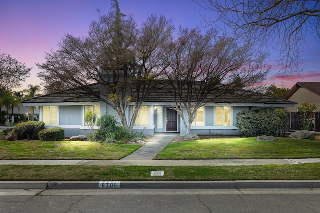 view of front of property featuring a lawn and stucco siding