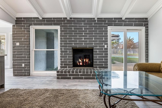 living room featuring ornamental molding, beamed ceiling, and a fireplace