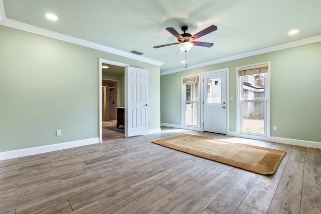 foyer entrance featuring ornamental molding, wood finished floors, visible vents, and baseboards