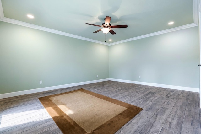 empty room with crown molding, wood finished floors, and baseboards