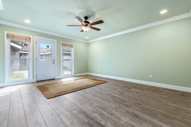 doorway to outside featuring a ceiling fan, crown molding, baseboards, and wood finished floors