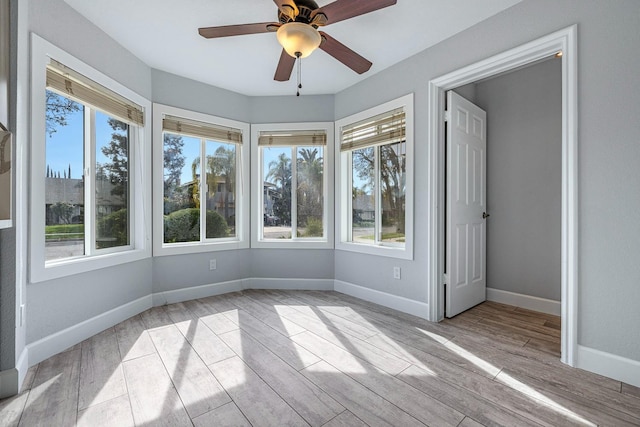 unfurnished sunroom featuring a ceiling fan