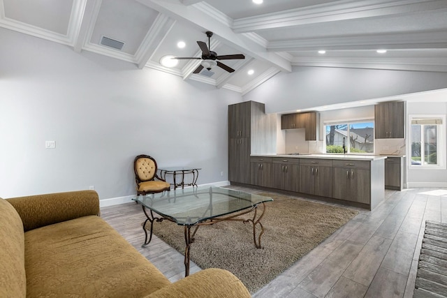 living area featuring baseboards, beamed ceiling, visible vents, and light wood-style floors