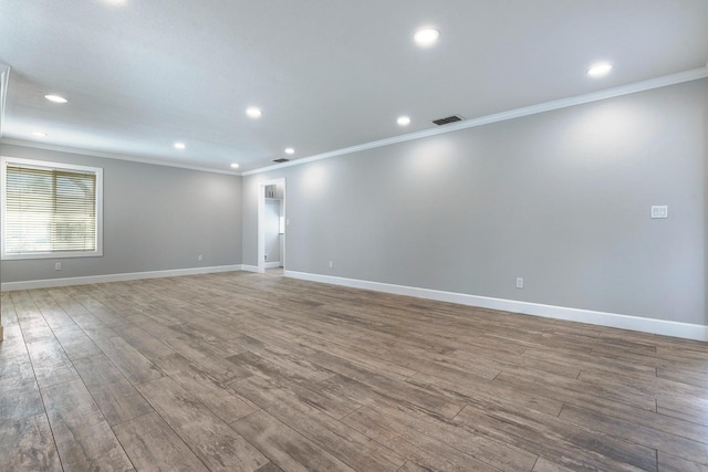 spare room featuring ornamental molding, recessed lighting, wood finished floors, and baseboards