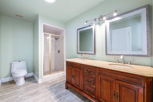 full bath featuring toilet, visible vents, a sink, and wood finished floors