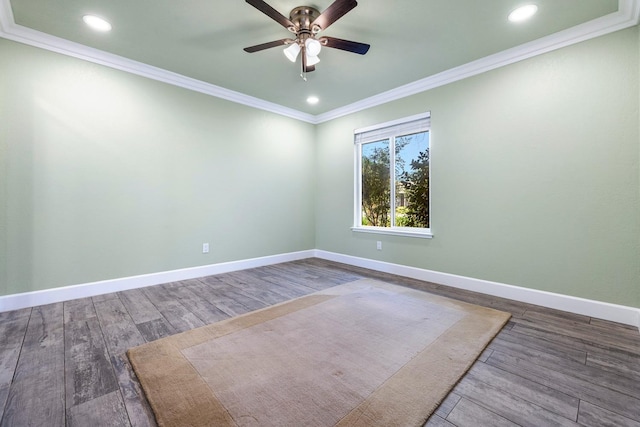 empty room featuring ornamental molding, baseboards, and wood finished floors