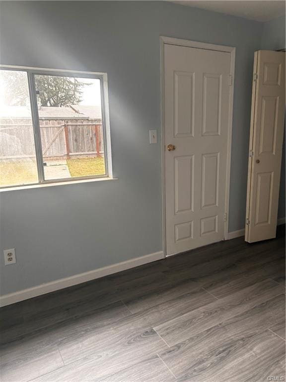 empty room featuring wood finished floors and baseboards