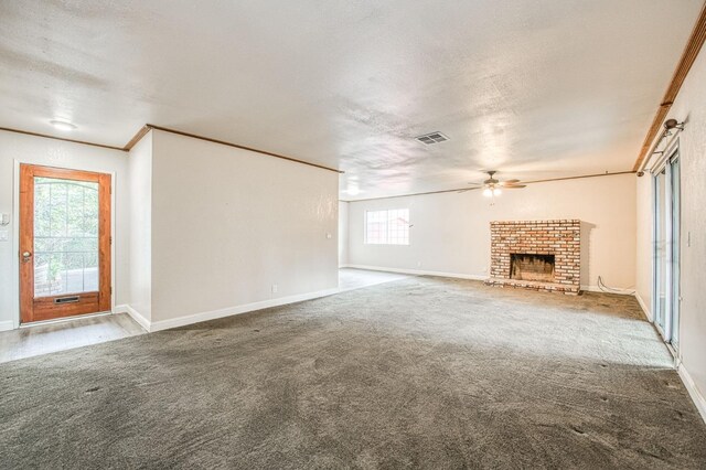 unfurnished living room with carpet floors, visible vents, a fireplace, and a textured ceiling