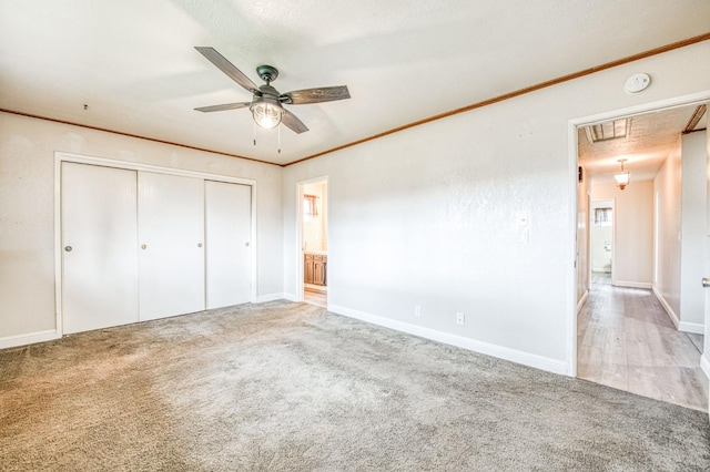 unfurnished bedroom with carpet floors, ornamental molding, and attic access