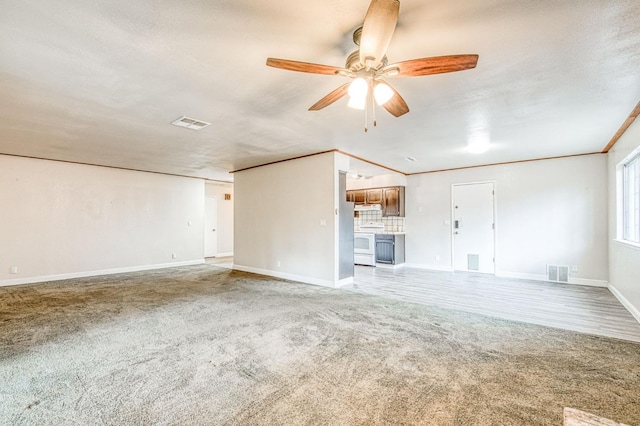 unfurnished living room with ceiling fan, crown molding, visible vents, and carpet flooring