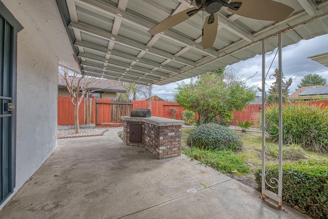 view of patio with area for grilling, a fenced backyard, and a ceiling fan