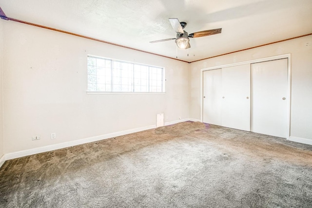 unfurnished bedroom with ornamental molding, a closet, carpet flooring, and baseboards