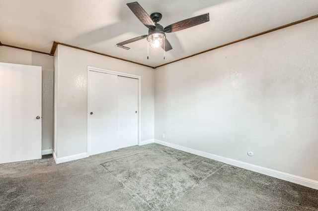 unfurnished bedroom with visible vents, a ceiling fan, crown molding, carpet floors, and a closet