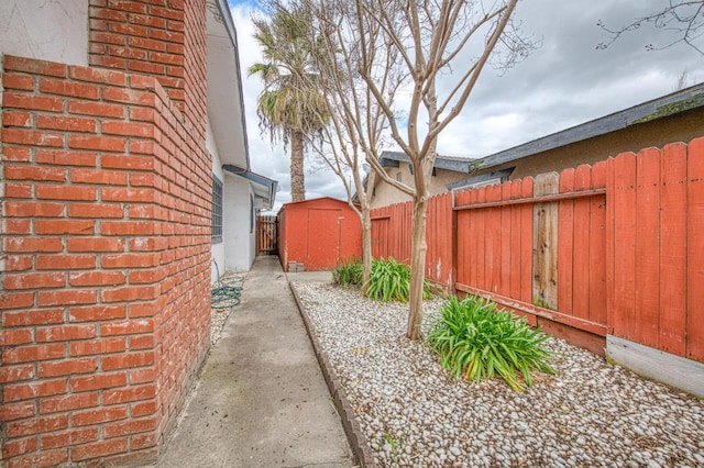 view of yard with a storage shed, an outbuilding, and a fenced backyard