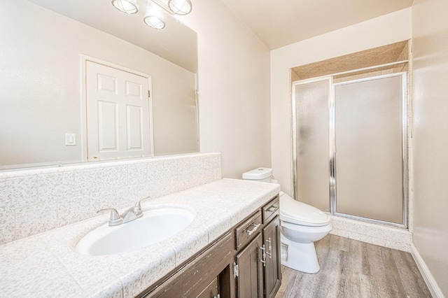 bathroom featuring vanity, a stall shower, wood finished floors, and toilet