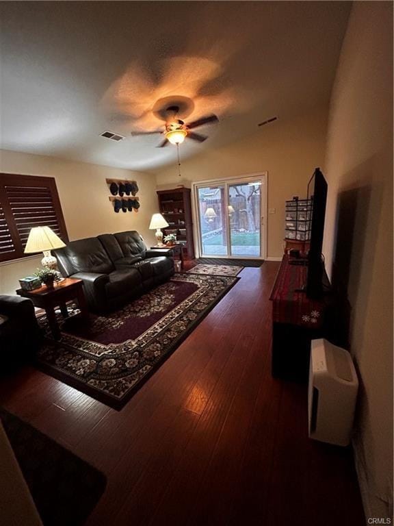 living room with ceiling fan, visible vents, and dark wood finished floors