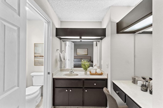 bathroom with a textured ceiling, toilet, and vanity