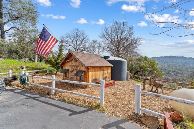 view of outbuilding featuring fence and an outdoor structure