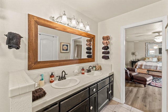 bathroom featuring double vanity, tasteful backsplash, connected bathroom, and a sink