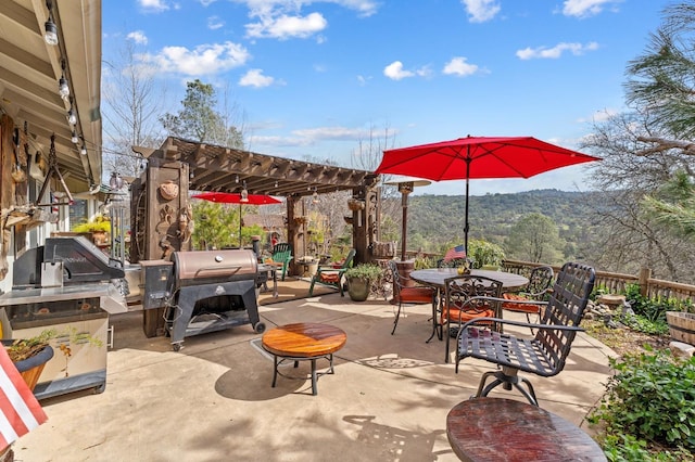 view of patio / terrace with a grill, outdoor dining area, a pergola, and area for grilling