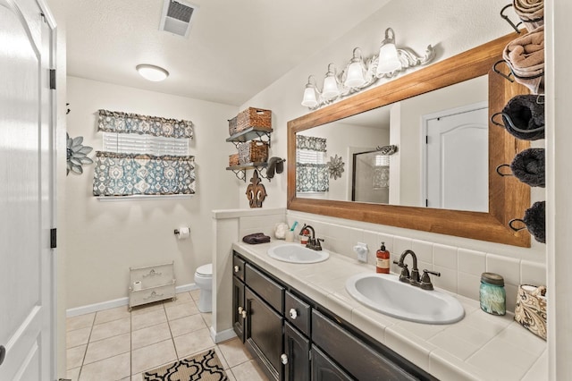 bathroom with tile patterned flooring, tasteful backsplash, visible vents, and a sink