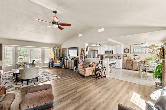 living area featuring light wood-type flooring, ceiling fan, and lofted ceiling