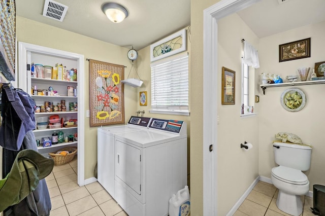 clothes washing area featuring laundry area, baseboards, visible vents, separate washer and dryer, and light tile patterned flooring