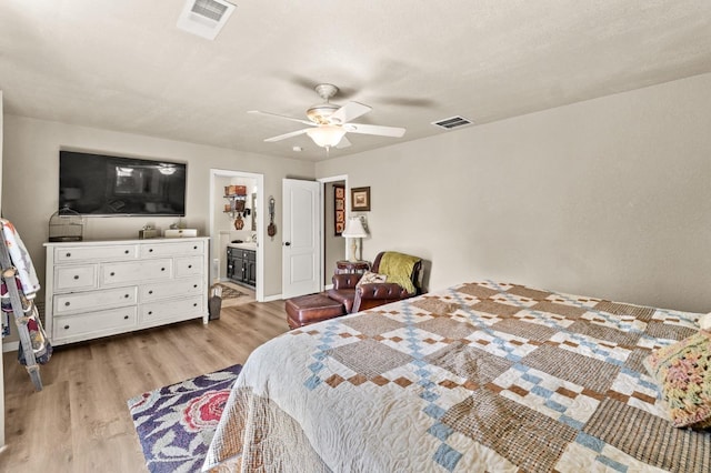 bedroom featuring light wood finished floors, visible vents, and a ceiling fan