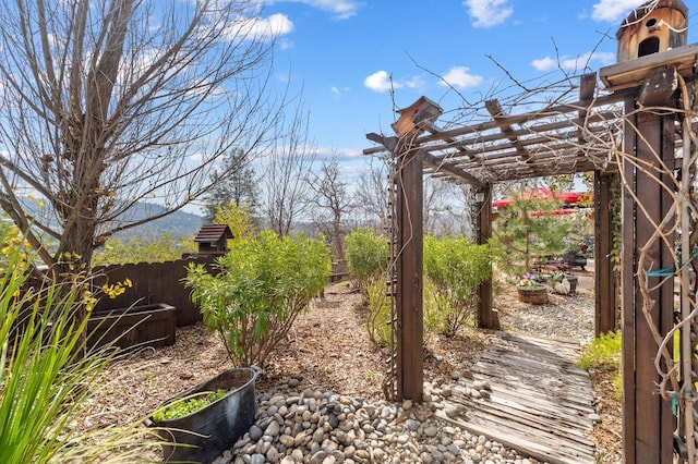 view of yard featuring fence and a pergola