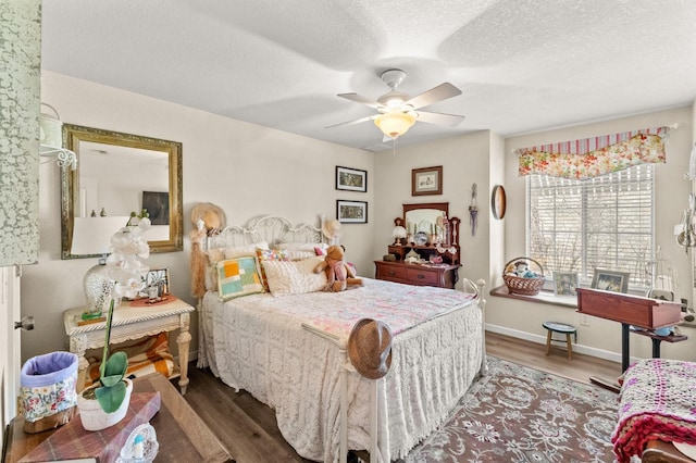 bedroom featuring a textured ceiling, ceiling fan, wood finished floors, and baseboards