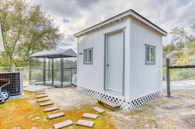 view of outdoor structure with an outdoor structure, cooling unit, and fence