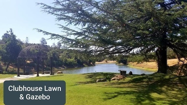 view of property's community with a lawn and a water view