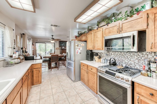 kitchen with light tile patterned floors, visible vents, stainless steel appliances, light countertops, and tasteful backsplash