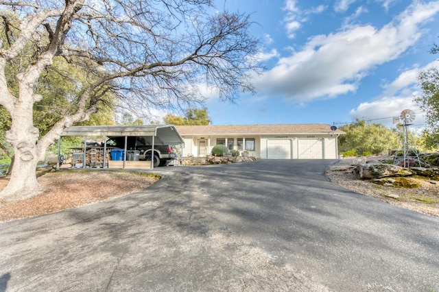 single story home with a carport, an attached garage, and driveway