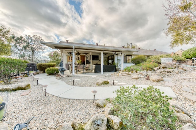 rear view of property with a ceiling fan, a patio area, and fence