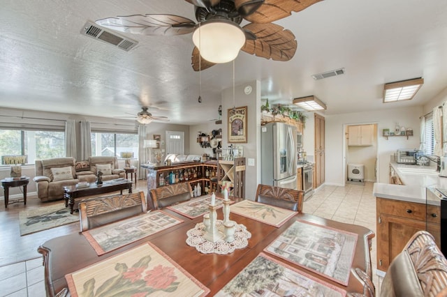 dining space with a wealth of natural light, visible vents, and light tile patterned floors