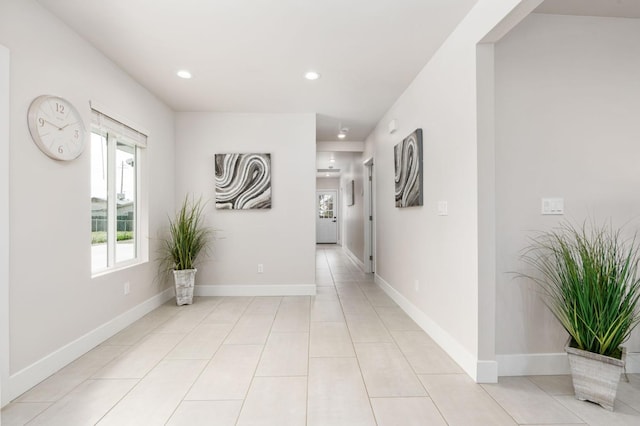 hallway with light tile patterned floors, baseboards, and recessed lighting