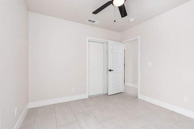 unfurnished bedroom with baseboards, visible vents, ceiling fan, and a closet