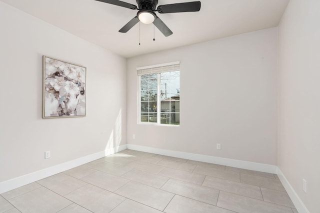 empty room with light tile patterned flooring, a ceiling fan, and baseboards