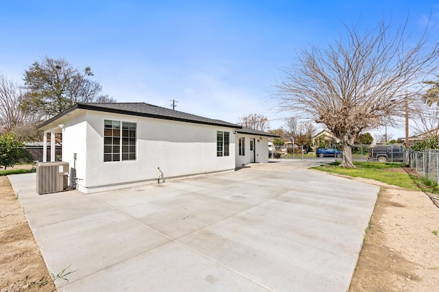 view of home's exterior featuring central AC, a patio area, fence, and stucco siding